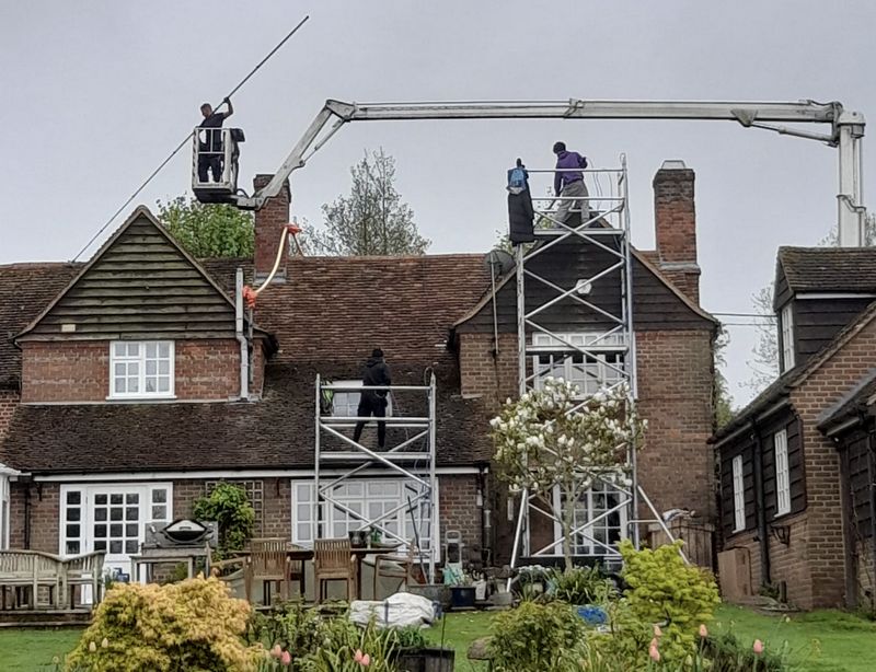 Manual roof moss removal using scaffolding and cherry picker